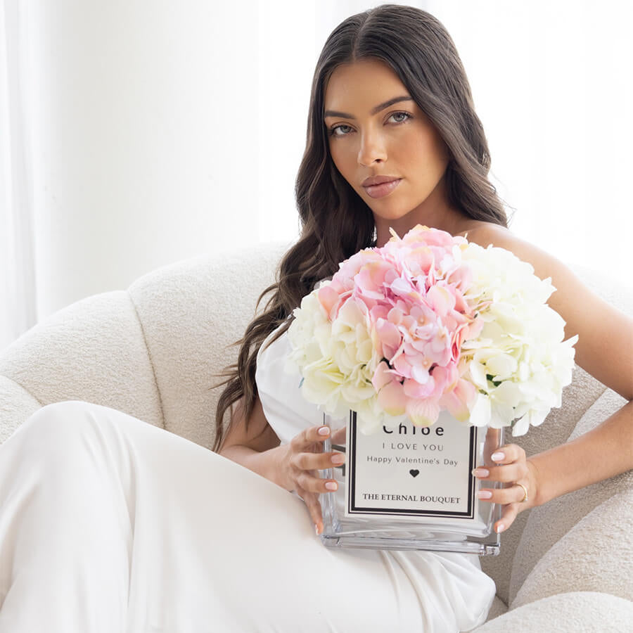 Woman holding a personalised glass vase with pink and white scented silk hydrangeas by The Eternal Bouquet