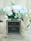 Everlasting mixed eden blooms, perfect for gifts to loved ones. The beautiful flowers, with hues of white, blue, green, and hints of yellow are encased in a beautiful sleek rectangular glass vase, with a personalised label placed on the middle. 