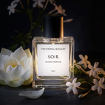 Perfume bottle labeled 'SOIR' with flowers on a dark background