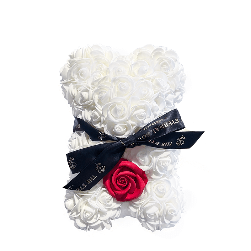 A charming floral teddy bear designed with crisp white everlasting roses and a striking single red rose accent at the base. Tied together with a sleek black ribbon featuring The Eternal Bouquet’s gold branding, this piece offers a playful yet elegant touch—ideal as a statement gift for Valentine’s Day, romantic gestures, or modern home styling.