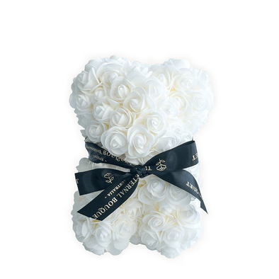 A luxurious everlasting white rose teddy bear from The Eternal Bouquet, crafted from delicate roses and tied with an elegant black and gold branded ribbon. This timeless piece makes a perfect gift for weddings, anniversaries, baby showers, or as a chic decorative item to brighten any modern space.