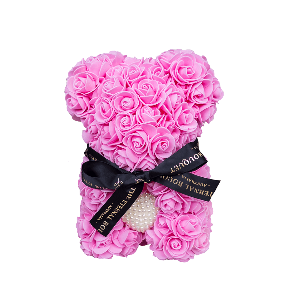 A handcrafted rose teddy bear from The Eternal Bouquet, made entirely of delicate pink everlasting roses and featuring a pearl heart detail at its center. Finished with a luxurious black ribbon embossed with gold branding, this adorable and romantic gift is perfect for anniversaries, birthdays, or showing someone just how much they mean to you.