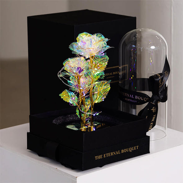 Three elegant white galaxy roses illuminated with warm LED lights inside a glass dome, a timeless gift idea for birthdays, anniversaries, and Mother's Day.