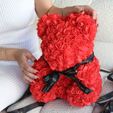 A handcrafted everlasting red rose teddy bear from The Eternal Bouquet, adorned with a sleek black ribbon featuring the brand’s logo. This luxurious and timeless gift makes a bold romantic statement, perfect for anniversaries, Valentine’s Day, or simply to show someone how deeply they’re loved.