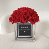 Beautiful red everlasting roses, encased in a sleek rectangular glass vase, with a personalised label. 