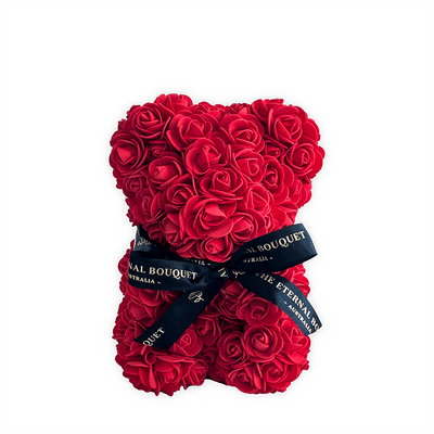 A stunning red rose teddy bear from The Eternal Bouquet, crafted entirely from vibrant everlasting roses and tied with an elegant black ribbon featuring gold foil branding. A romantic and lasting alternative to traditional floral gifts, this bear is perfect for Valentine’s Day, anniversaries, or any special occasion where love and thoughtfulness are celebrated.